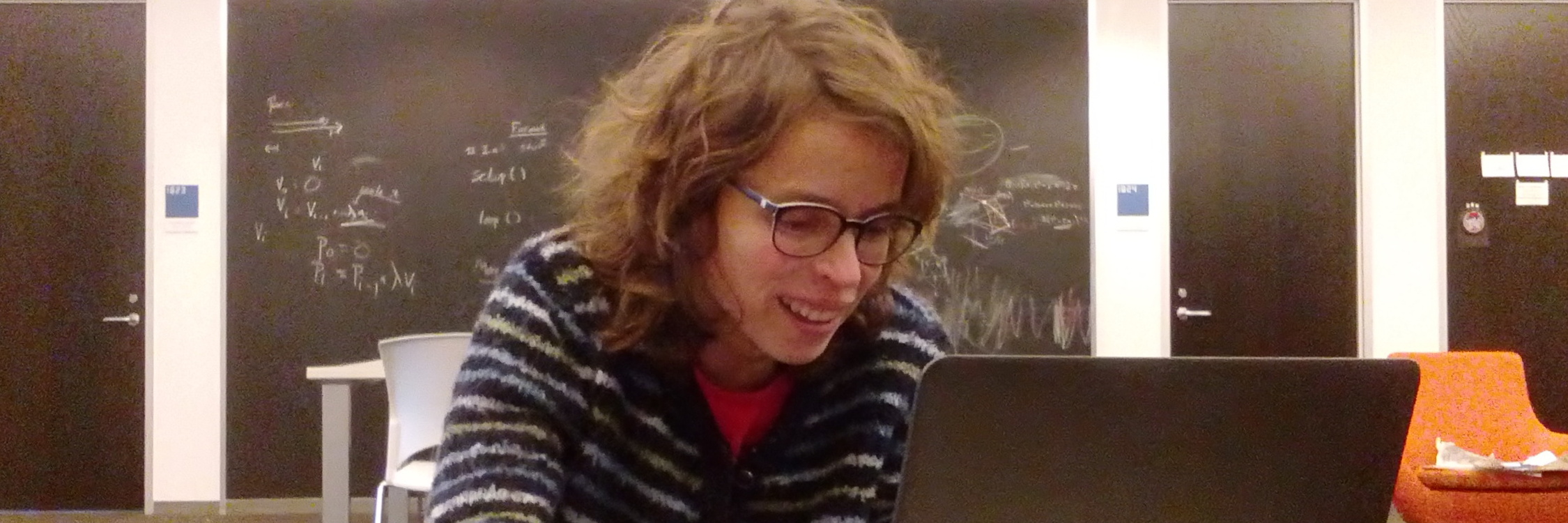 Alba Málaga travaillant joyeusement sur un ordinateur.