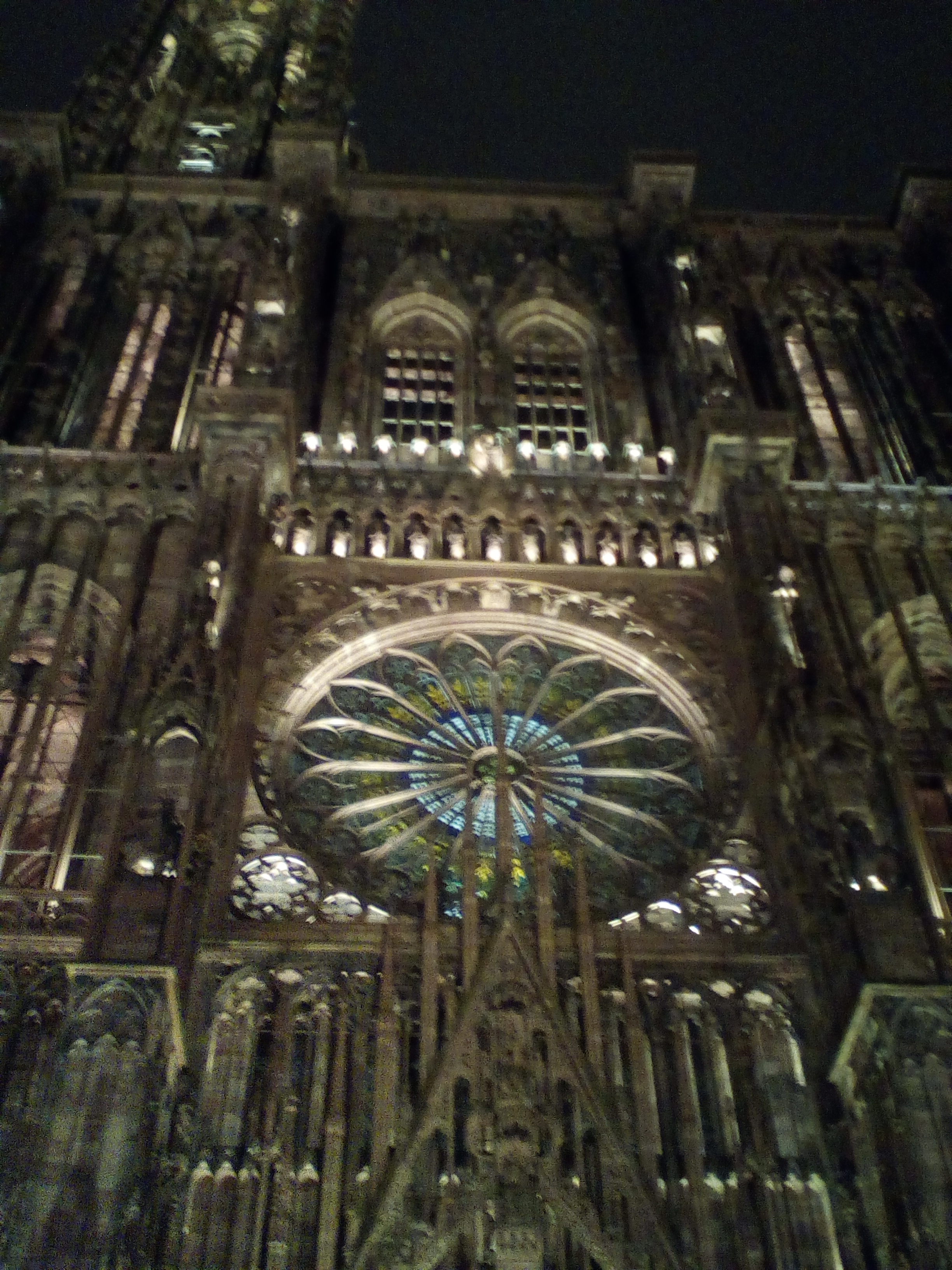 Vue partielle de la cathédrale strasbourgeoise. Au centre de la photographie on voit la fameuse rosette multicolore. Photo prise de nuit.